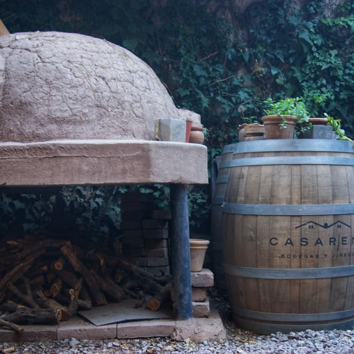 Barrica de vino junto a un horno de barro